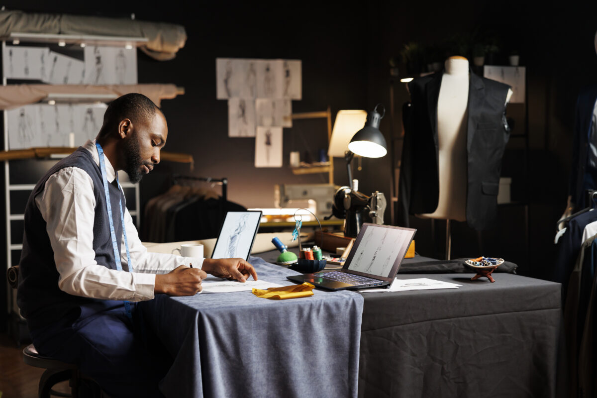 A fashion designer man designing with his digital gadgets 