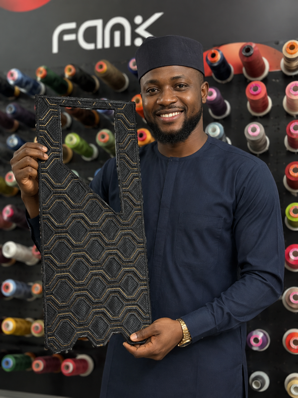 A man holidng an agbada embroidery cape
